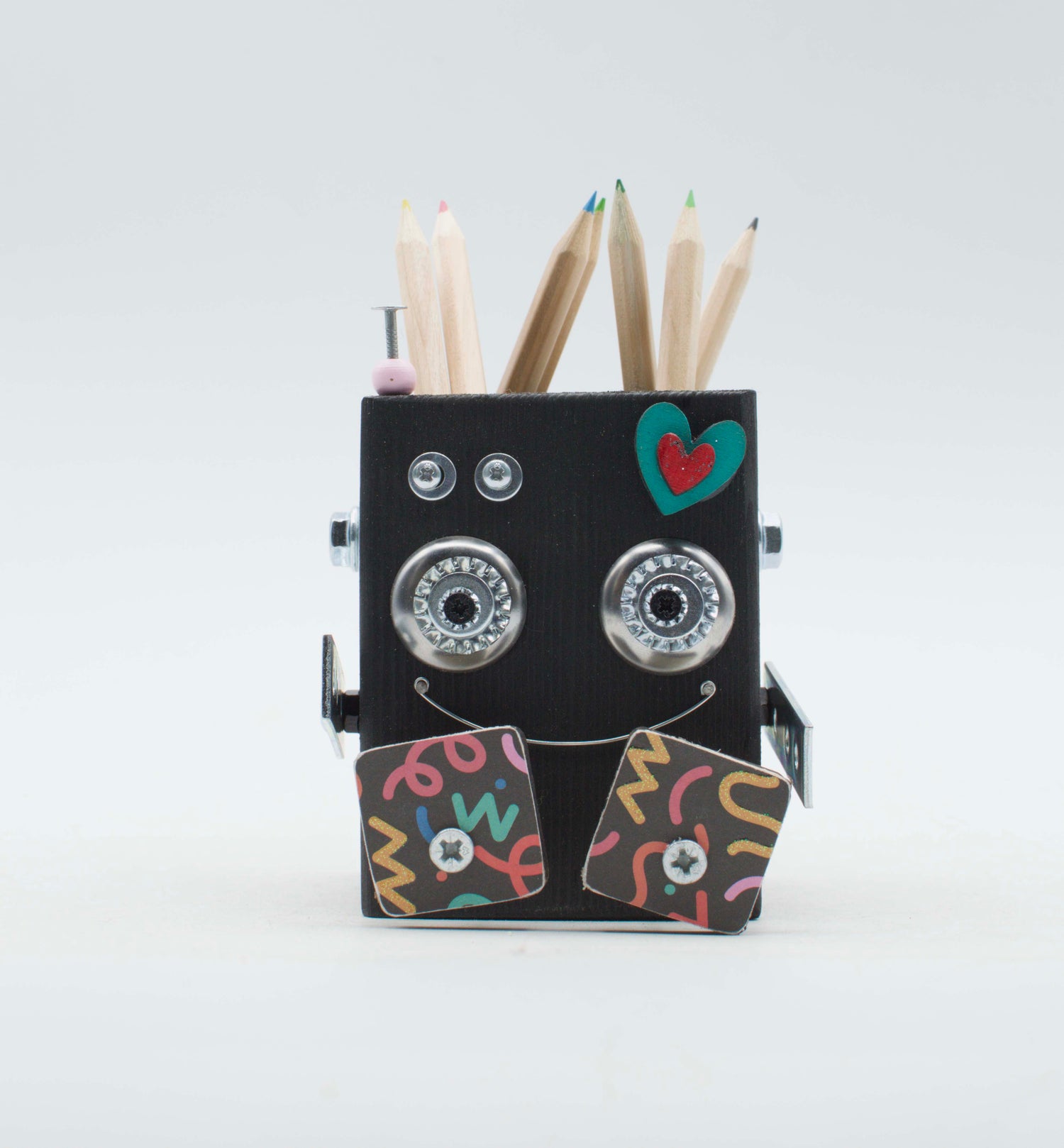 Porta Penne porta penne robot nero con occhi decorati argento, guance colorate e cuore turchese sulla fronte.