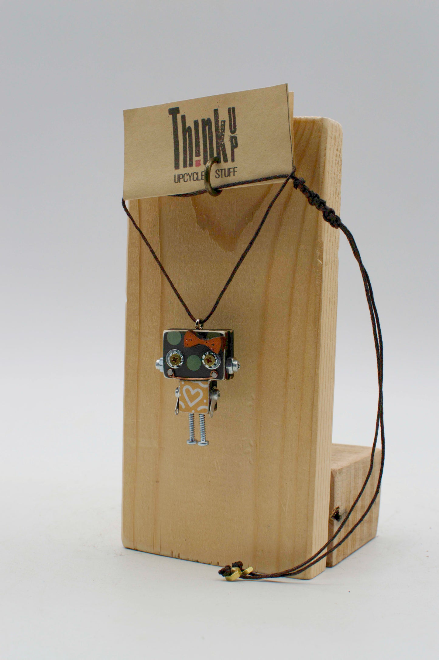 Ciondolino robot in legno tagliato a laser con pendente a forma di robot argentato e cuore inciso sul petto su supporto in legno