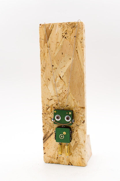 Ciondolo robot verde in legno tagliato a laser con occhi metallici e braccia dorate su collana pendente fatta a mano