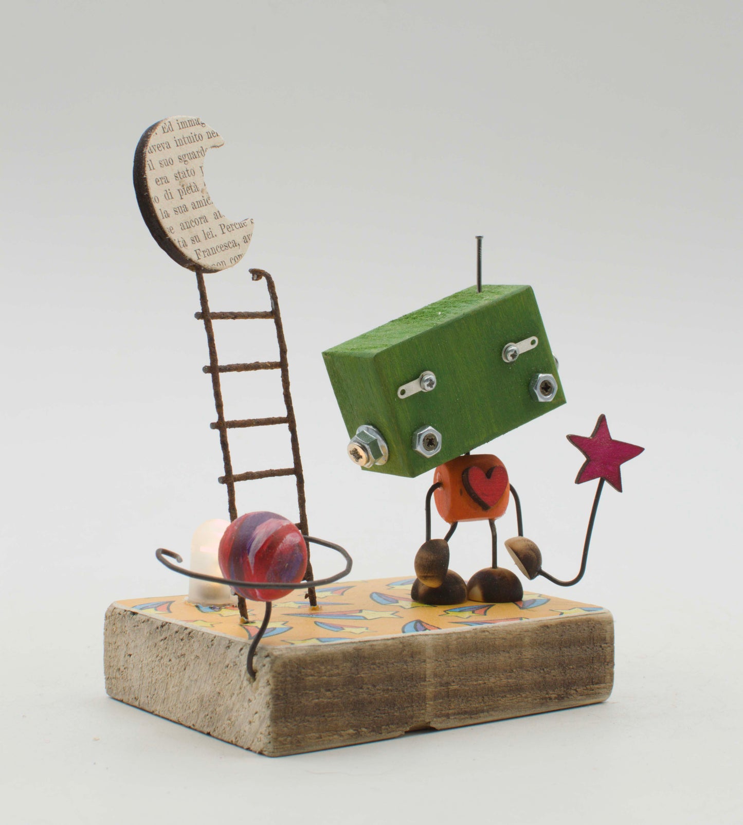 Diorama scultura luminosa robot verde con cuore arancione e braccia a filo che tiene una stella rossa fatta a mano