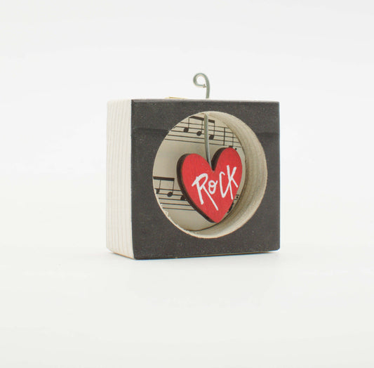 Piccolo quadro artigianale in legno nero con cuore rosso e scritta rock su fondo di spartito musicale