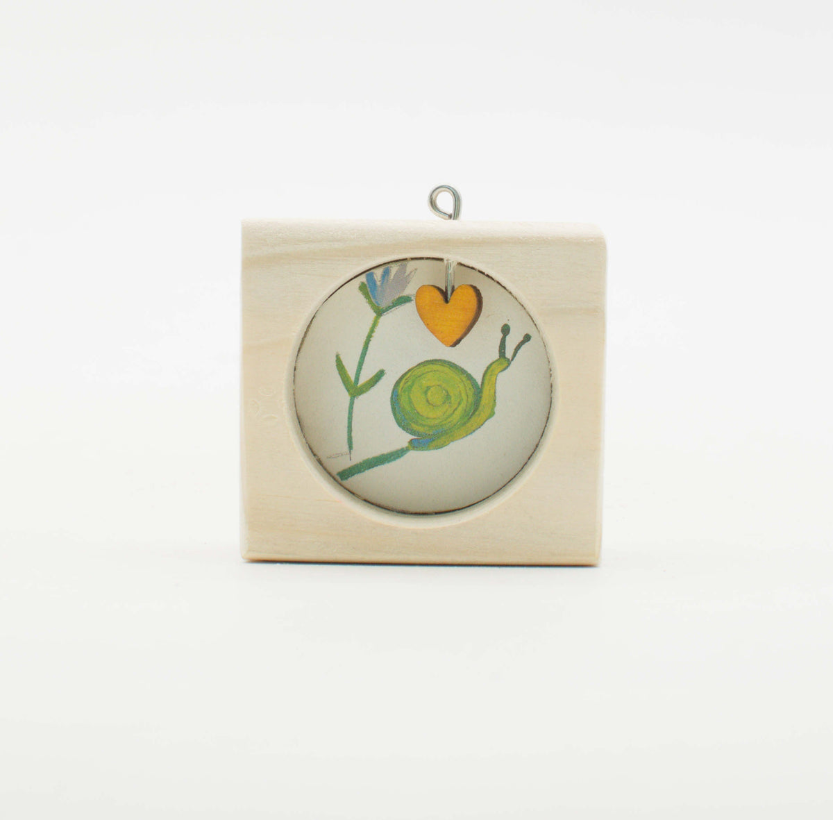 Piccolo quadro artigianale in legno con illustrazione a mano di una lumaca verde e cuore arancione in vetro circolare