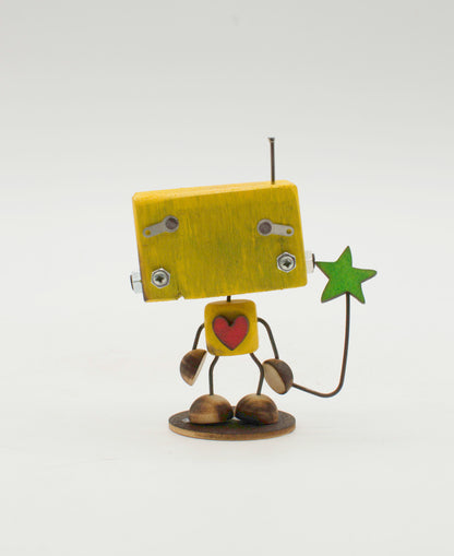 Minibot scultura robot fatto a mano in legno giallo con cuore rosso sul petto che tiene una stella verde