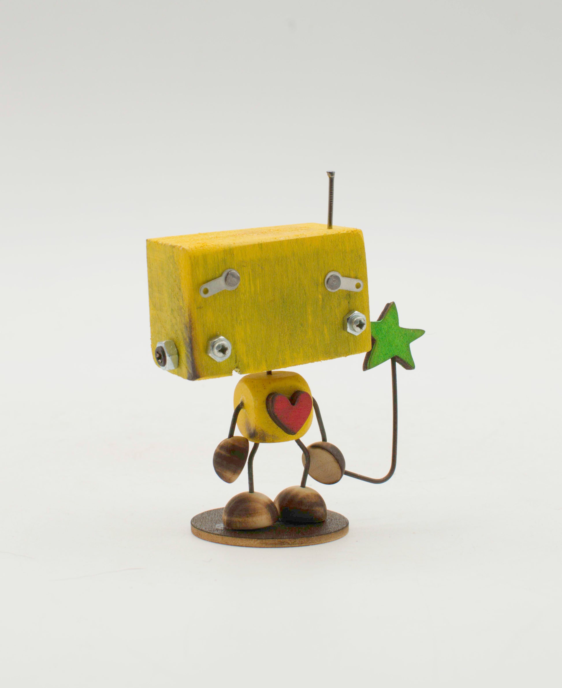 Minibot scultura robot fatto a mano giallo in legno con occhi metallici cuore e stella verde in mano