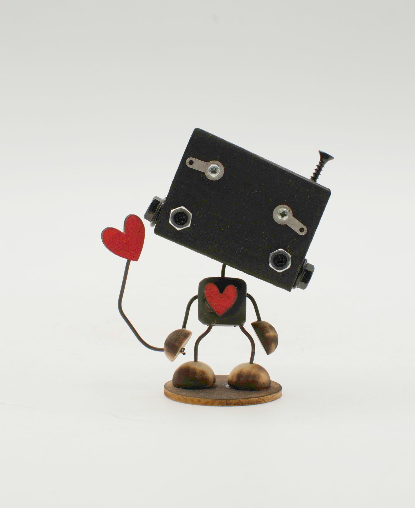 Scultura minibot robot fatto a mano in metallo nero con dettagli a forma di cuore rosso e viti decorativi