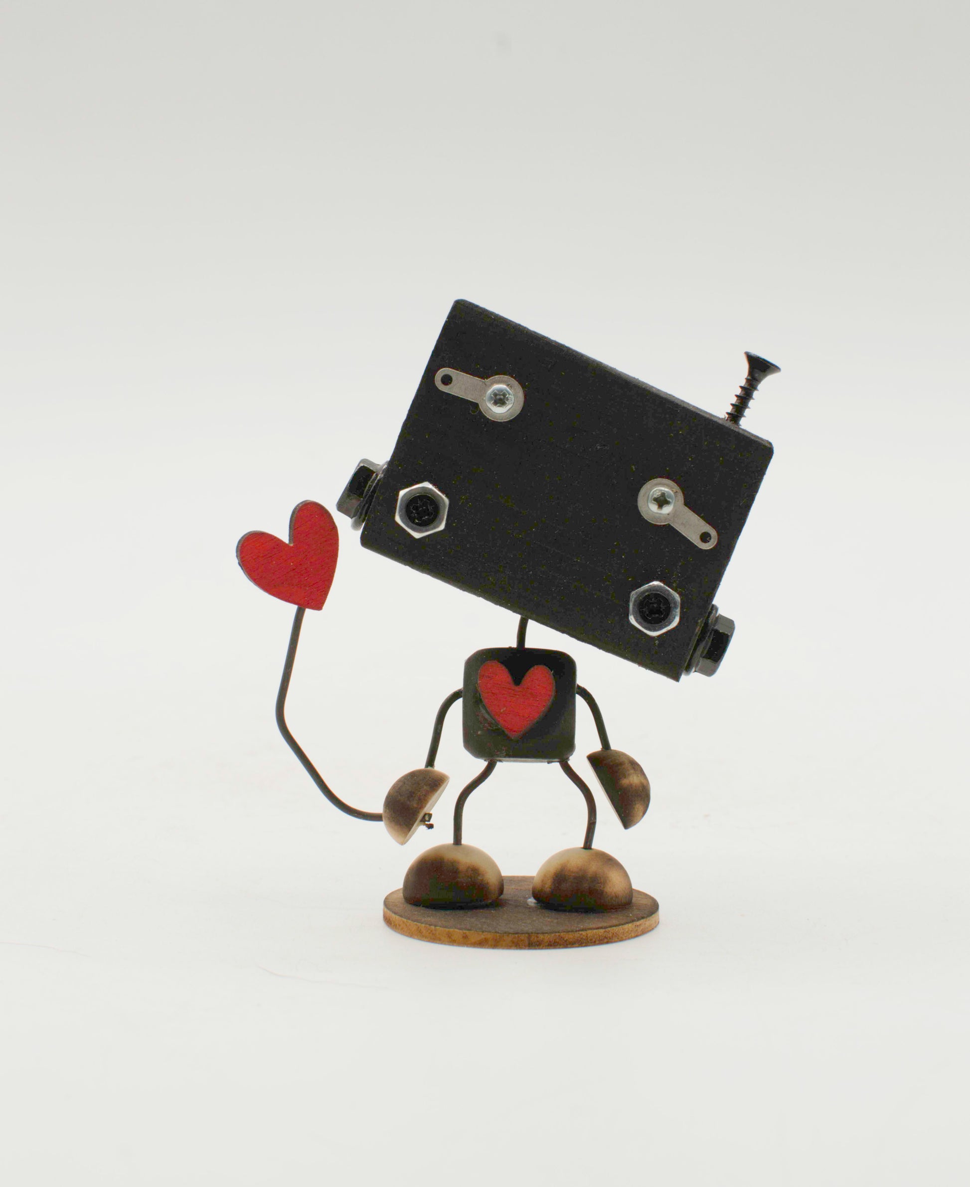 Scultura minibot robot fatto a mano in metallo nero con dettagli a forma di cuore rosso e viti decorativi