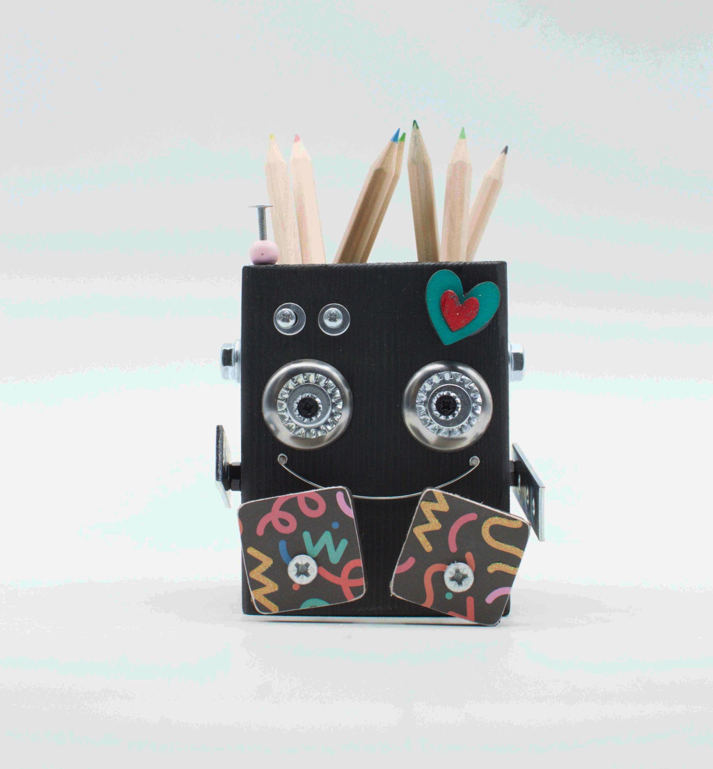 Portapenne a forma di robot fatto a mano nero con occhi metallici argento e decorazioni colorate sul viso