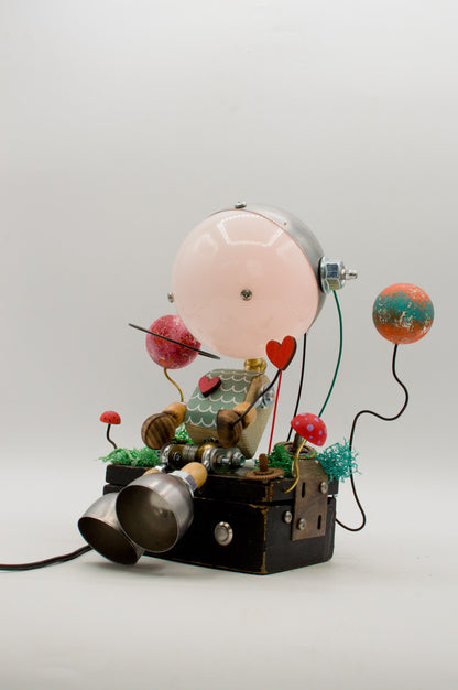 Lampada robot artigianale steampunk con globo rosa, accenti metallici e decorazioni colorate in metallo riciclato pezzo unico