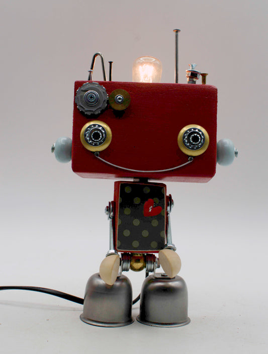 Lampada da tavolo robot beat steampunk con testa rossa, occhi cerchiati di ottone e parti metalliche riciclate