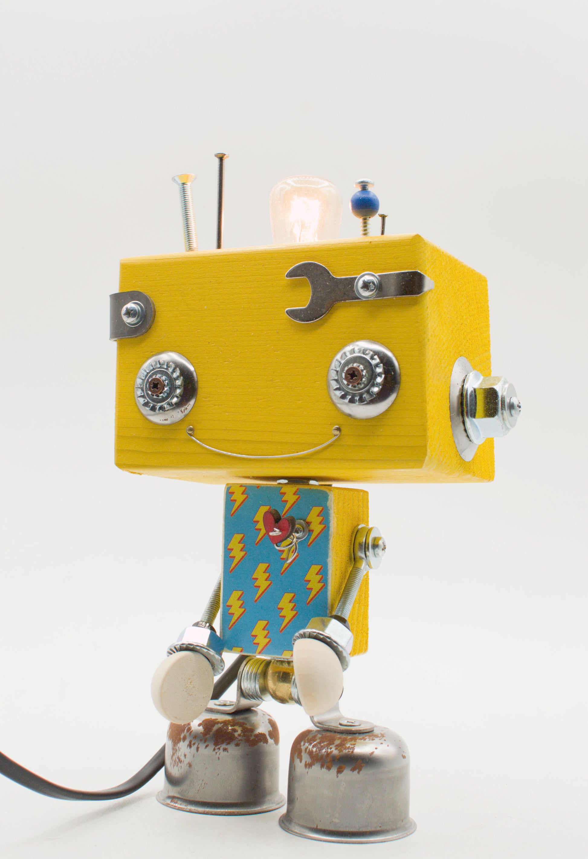 Lampada da tavolo robot beat gialla in legno con occhi metallici bocca a chiave inglese e piedi a campana fatta a mano