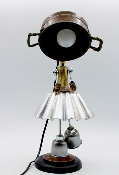 Lampada da tavolo robot stile ballerina con testa a vaso metallico, gonna argentata e gambe a campana steampunk