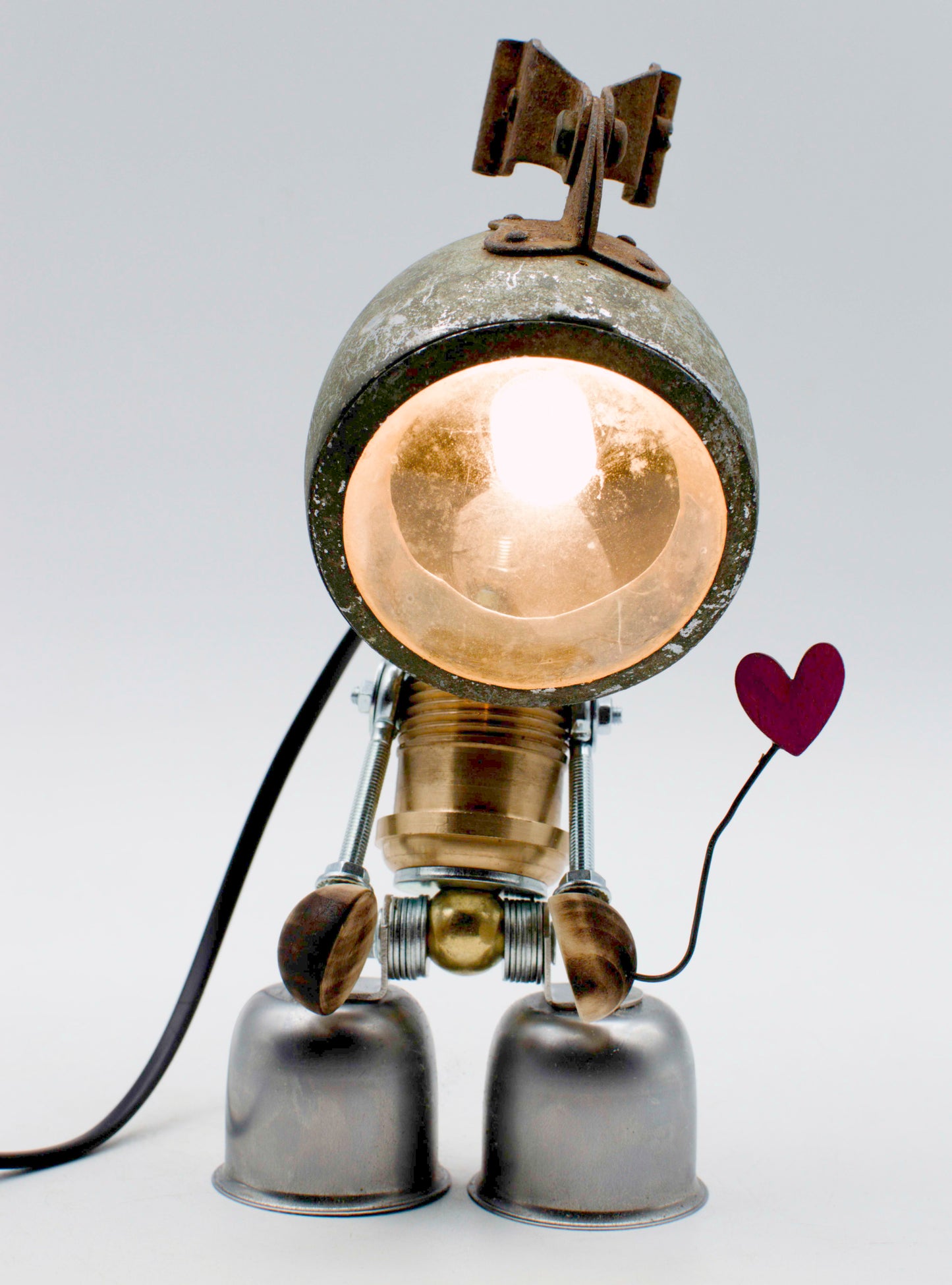 Robot lampada da tavolo stile fanale steampunk con corpo metallico invecchiato e globo di vetro ambra luminoso