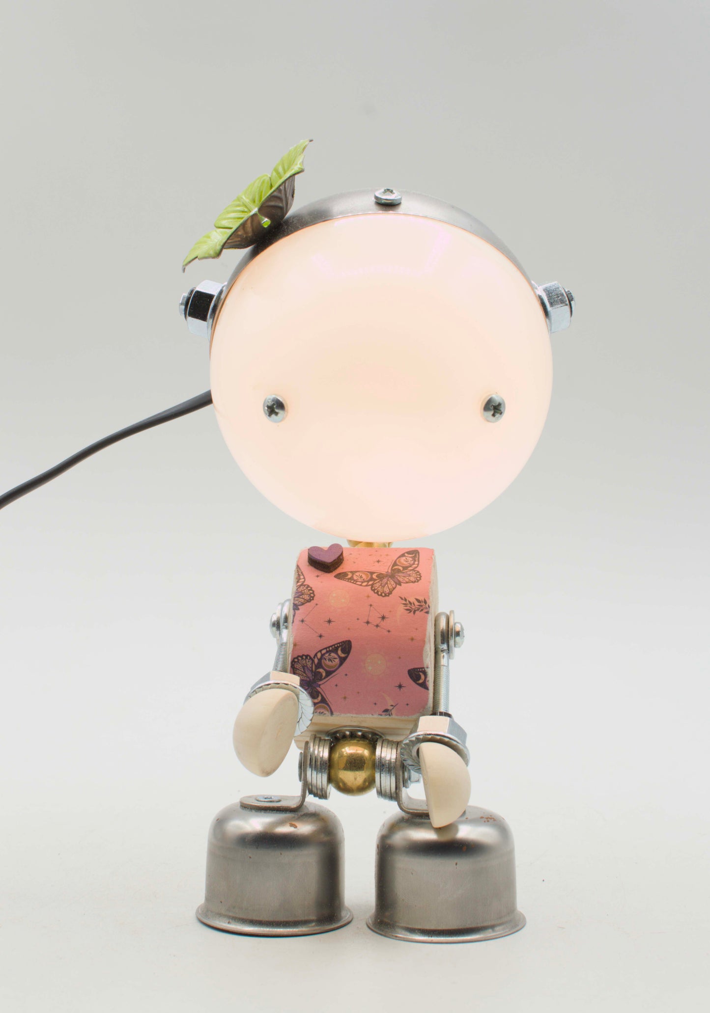Lampada da tavolo robot stile kodama steampunk con testa circolare luminosa traslucida e accenti metallici argento