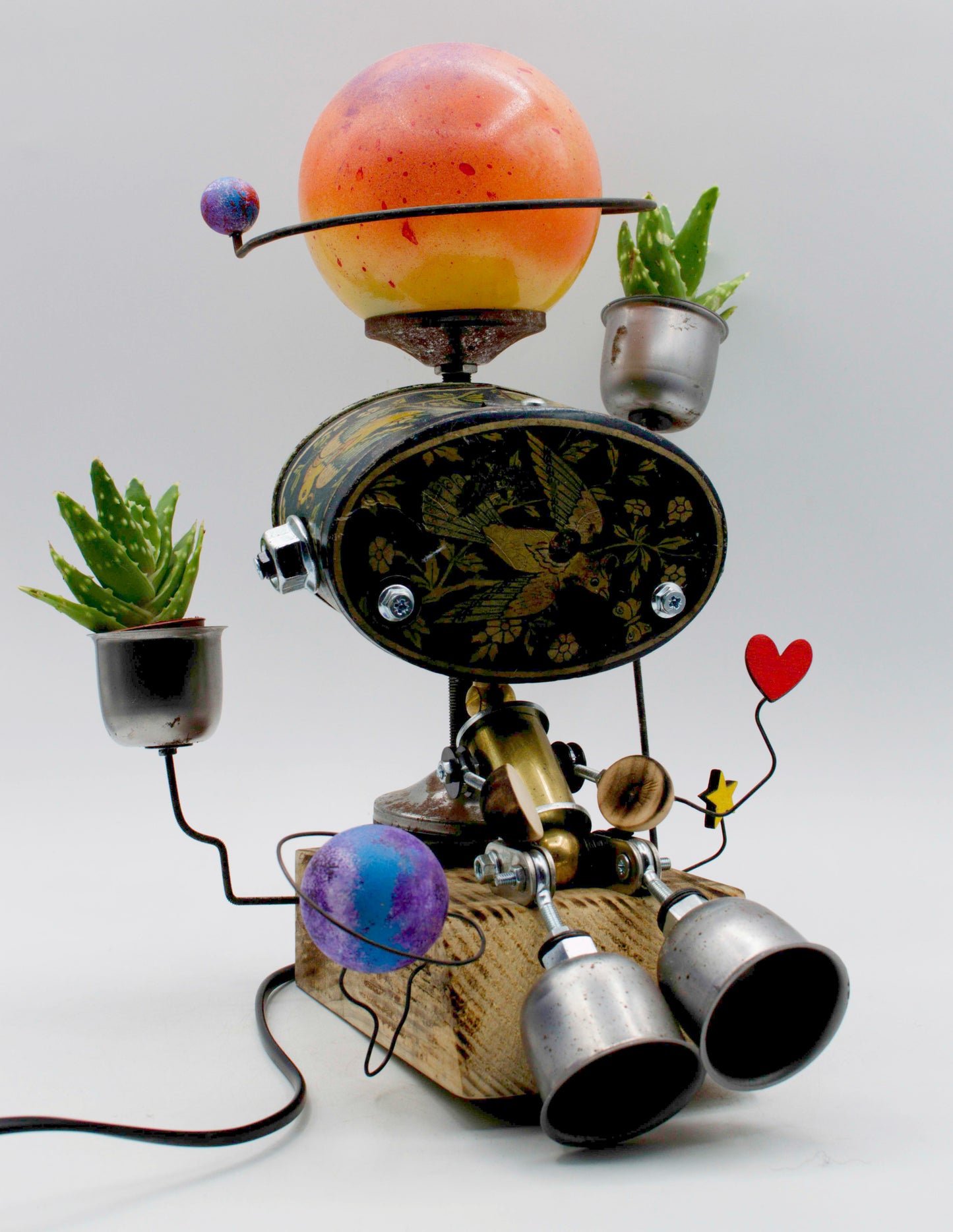Graziosa lampada creata robotica con testa sferica arancione gialla e corpo metallico in tavolo stile romantico fatta a mano