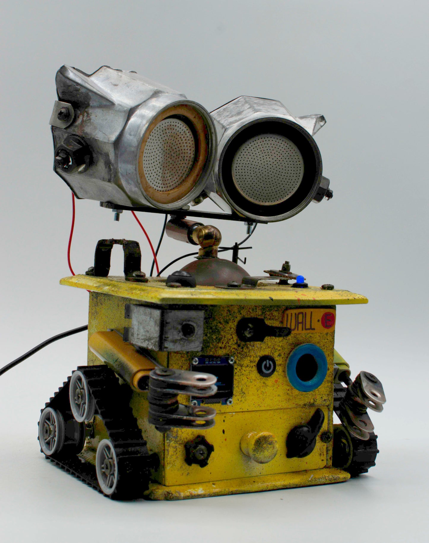 Graziosa lampada creata a mano stile WALL E in metallo giallo con grandi occhi rotondi e ruote tipo tank