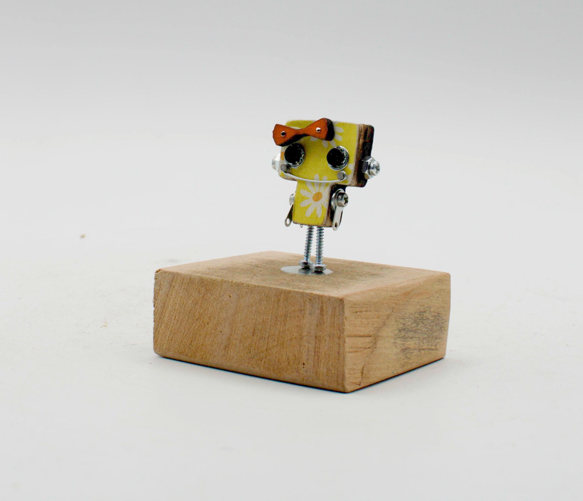 Spilla robot in legno tagliato a laser verde lime con motivo margherita bianca e fiocco marrone su base rustica