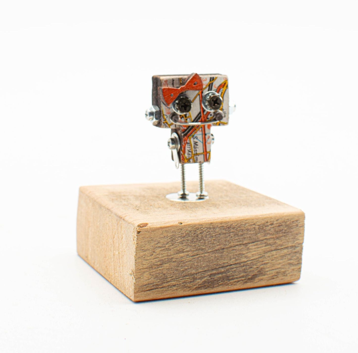 Spilla robot in legno tagliato a laser con corpo di carta riciclata e viti metalliche su base in legno rustico