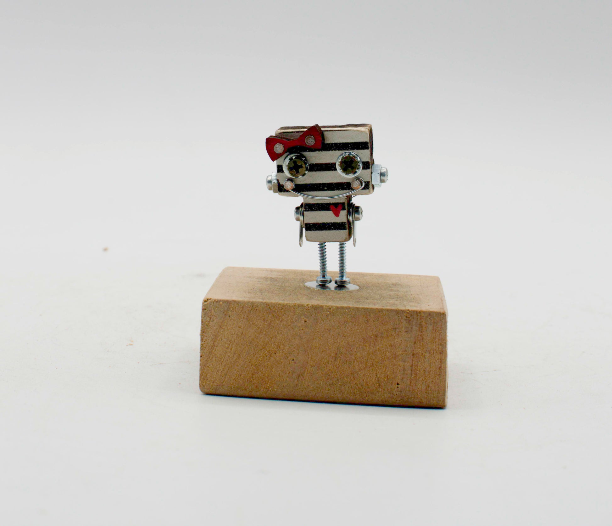 Spilla robot in legno tagliato a laser con figurina metallica miniatura con corpo a strisce argento e nero su base in legno