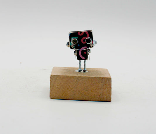 Spilla robot in legno tagliato a laser con figurina nera miniatura a occhi vite argento e gambe metalliche su base legno marrone