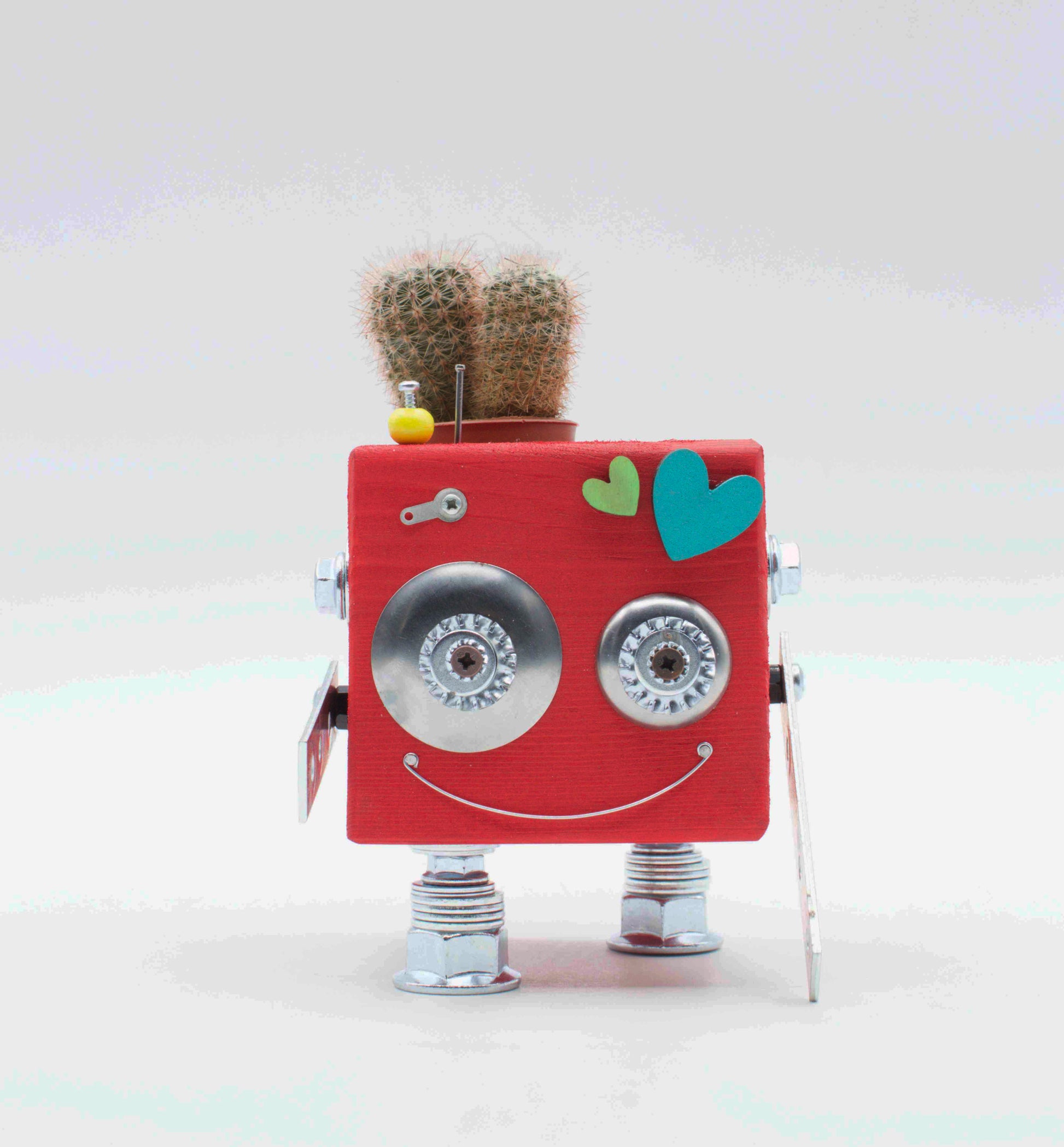Vaso a forma di robot rosa con occhi e gambe metallici argento e piccolo cactus in vaso legno fatto a mano