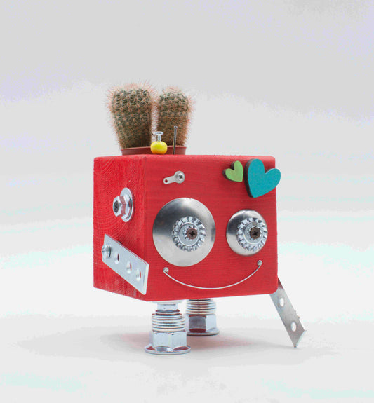 Vaso a forma di robot rosa a cubo con occhi metallici argento faccia sorridente e gambe in metallo porta pianta in legno fatto a mano