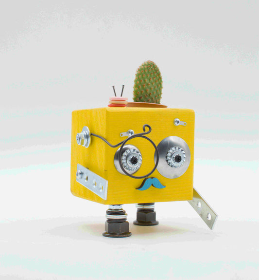 Vaso a forma di robot giallo a forma di cubo con occhi metallici argento, baffi blu e piccola pianta verde in legno fatto a mano